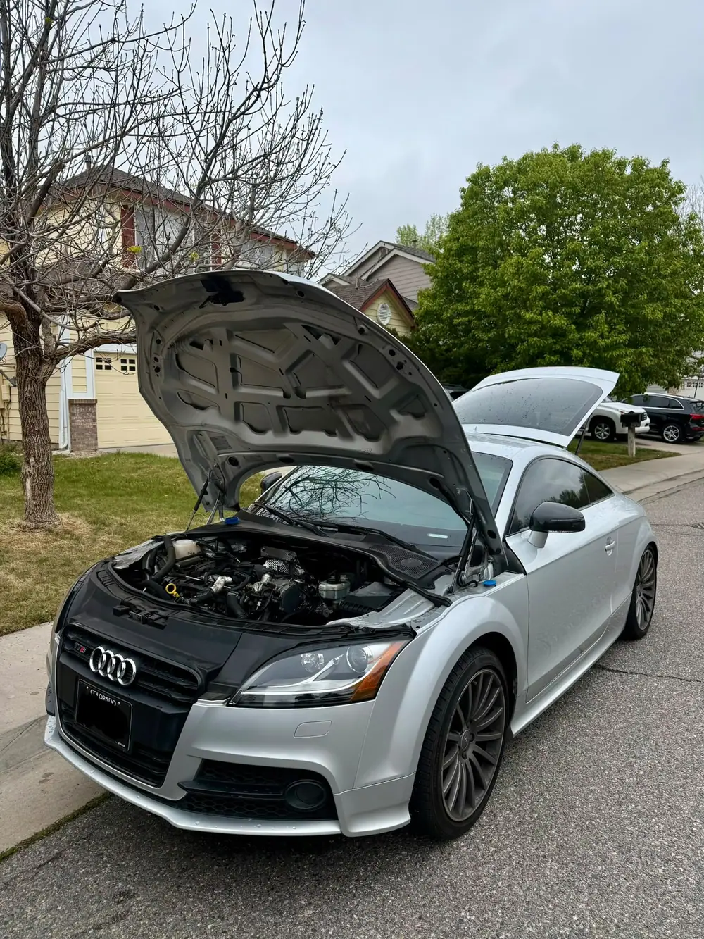 An Audi TTS on a Denver driveway with the hood up during a mobile service