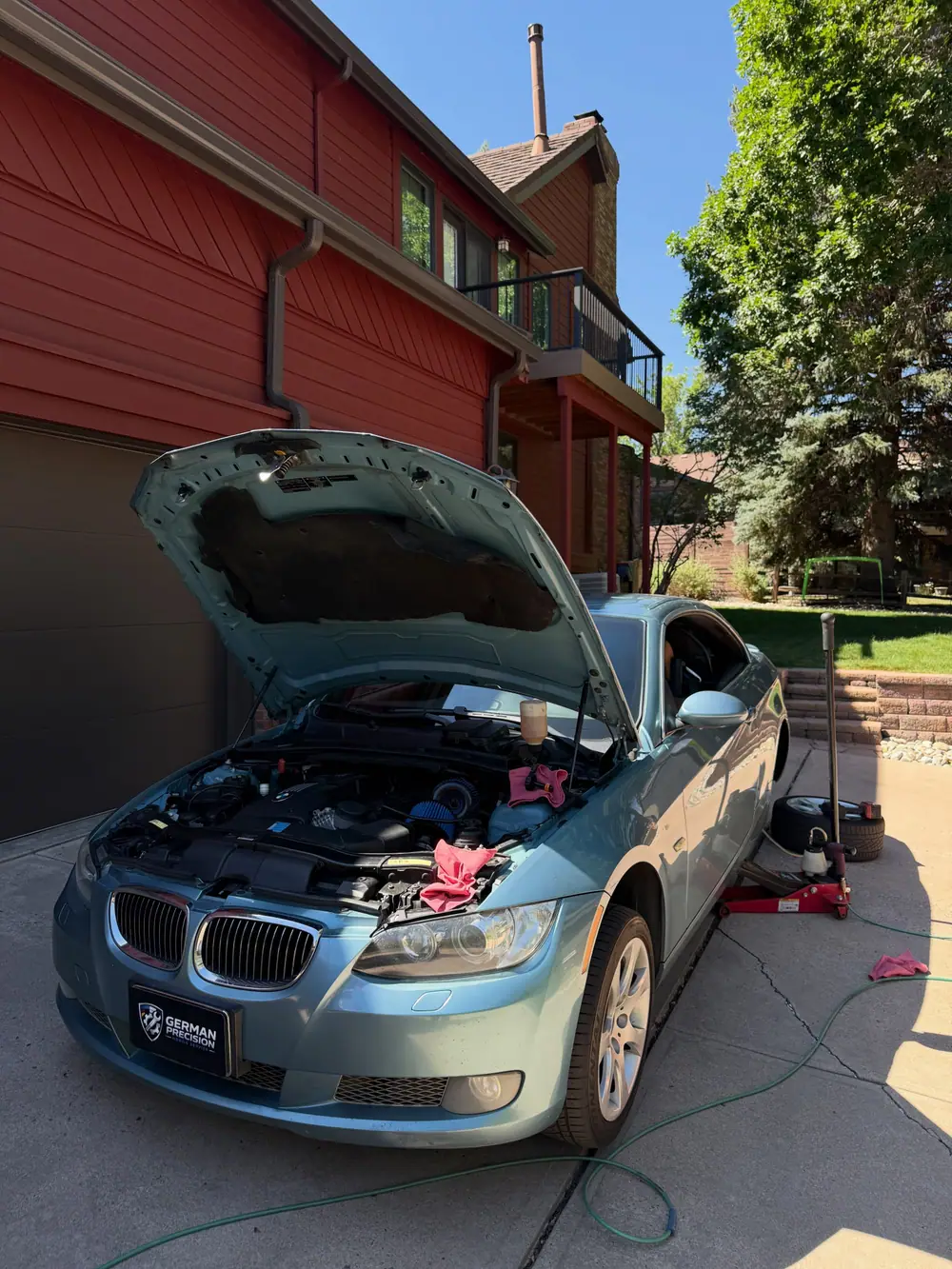 BMW 3 Series with the hood up during a driveway service call