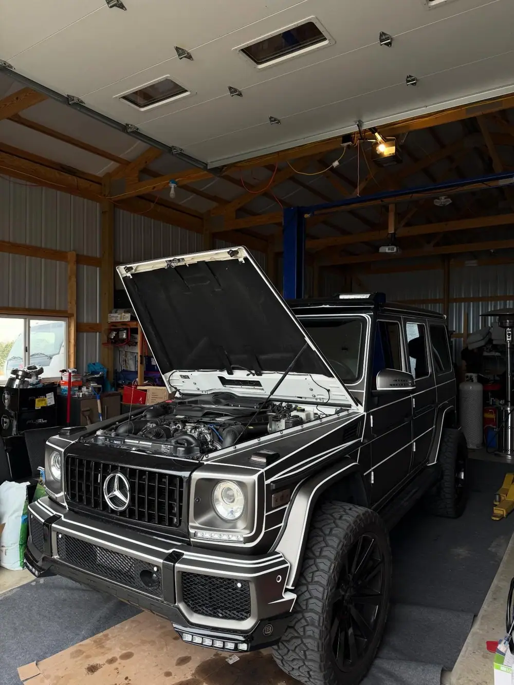 A Mercedes G-Class with the hood up during a service